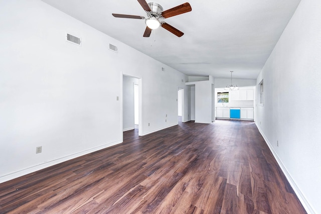 unfurnished living room with dark hardwood / wood-style floors, ceiling fan with notable chandelier, and vaulted ceiling