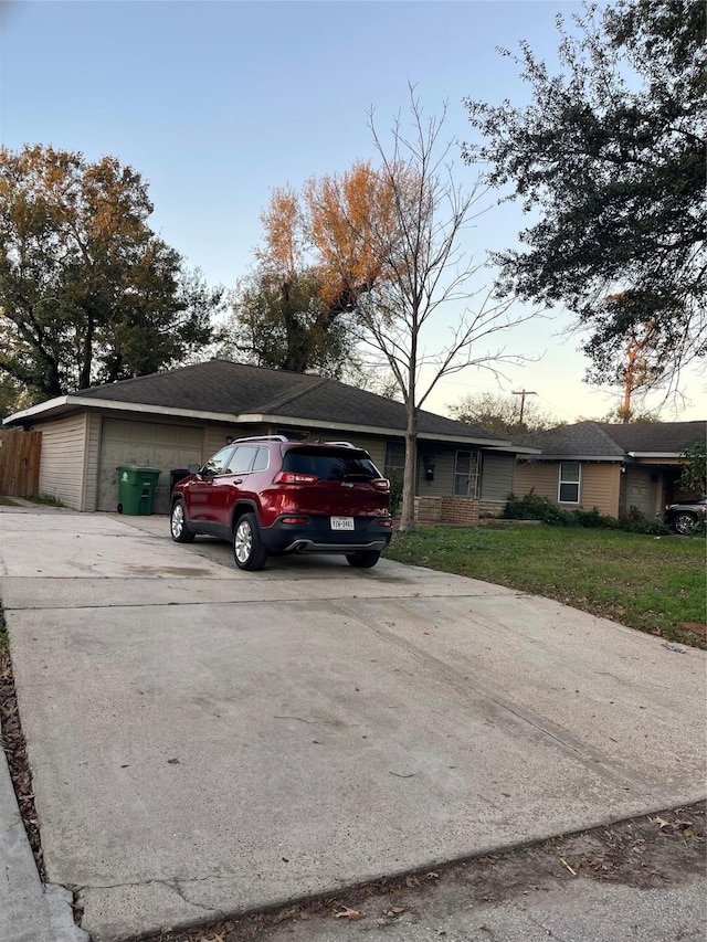 ranch-style home with a garage and a lawn