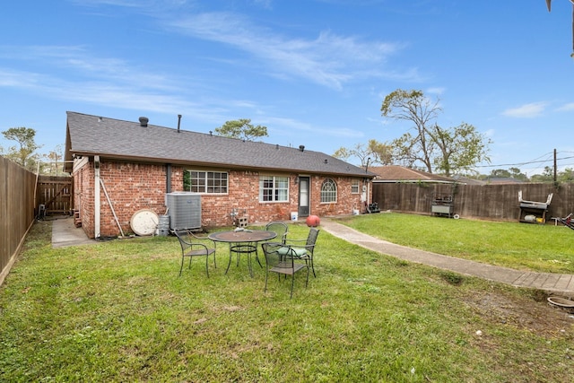 rear view of property with a yard and cooling unit