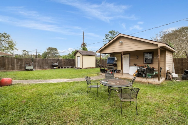 rear view of property with a lawn, a storage shed, and a patio