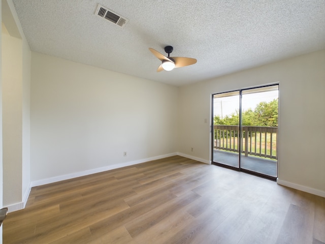 spare room with hardwood / wood-style flooring, ceiling fan, and a textured ceiling