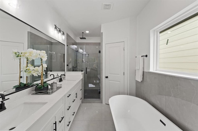 bathroom featuring tile patterned flooring, vanity, and shower with separate bathtub