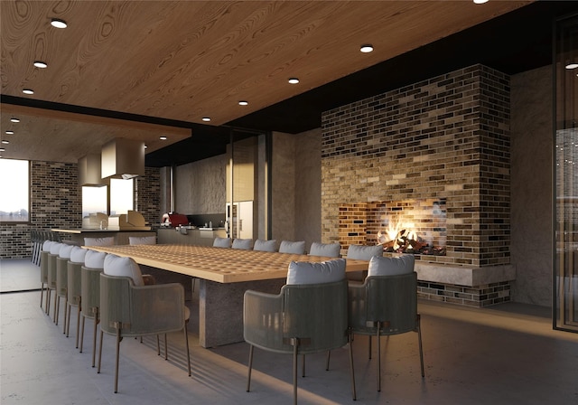 kitchen featuring a breakfast bar, wooden ceiling, kitchen peninsula, butcher block counters, and brick wall