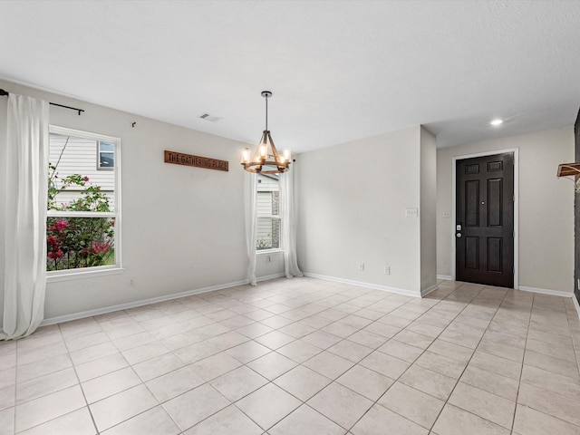 unfurnished room with light tile patterned floors and a notable chandelier