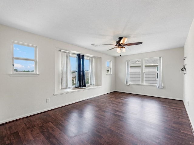 empty room with ceiling fan and dark wood-type flooring