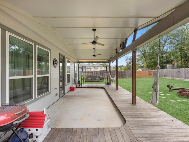 wooden terrace with an outdoor living space, a yard, and ceiling fan