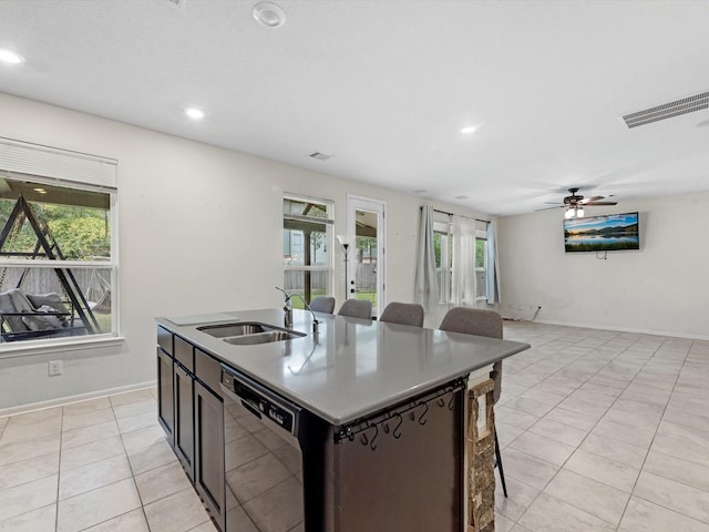 kitchen with dishwasher, a center island with sink, sink, ceiling fan, and light tile patterned floors