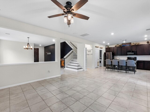 unfurnished living room with light tile patterned flooring and ceiling fan with notable chandelier