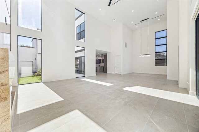 interior space with a towering ceiling and light tile patterned floors