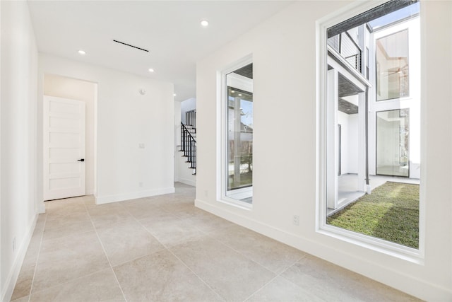 corridor featuring a wealth of natural light and light tile patterned floors