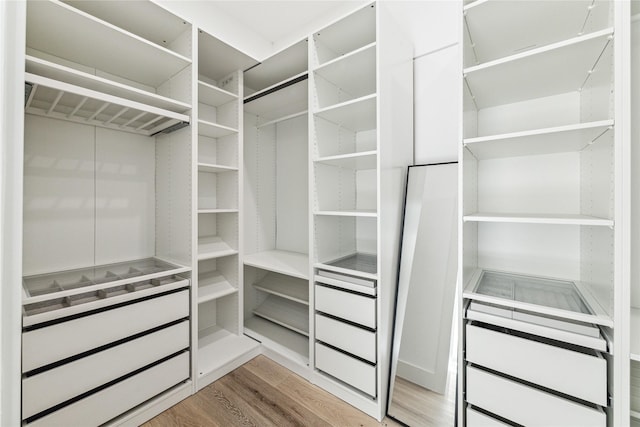 walk in closet with light hardwood / wood-style flooring