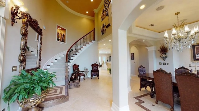 tiled entrance foyer with a high ceiling and an inviting chandelier