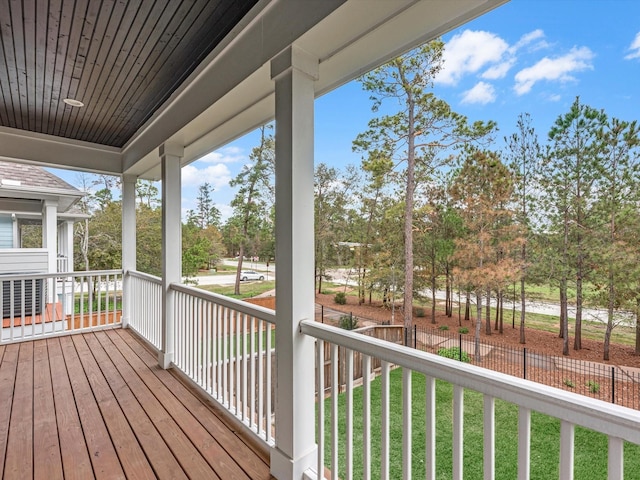 wooden deck with a lawn and a porch