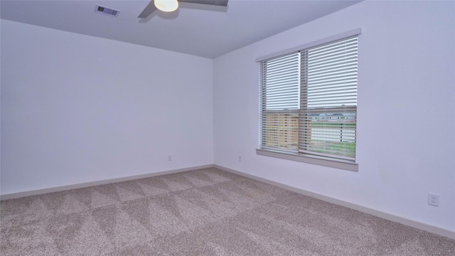 empty room featuring ceiling fan and light colored carpet