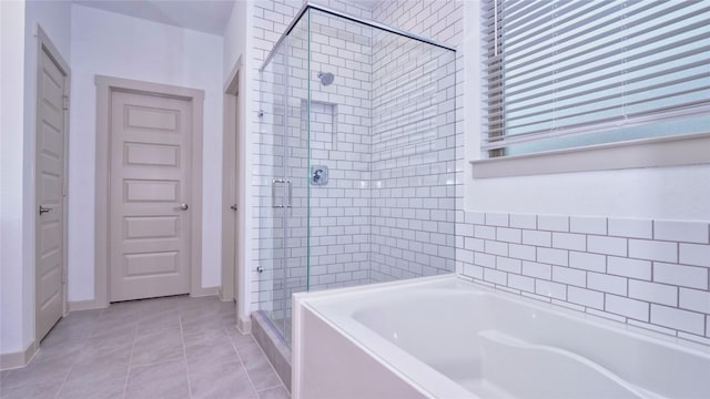 bathroom with tile patterned flooring and shower with separate bathtub