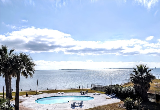 view of swimming pool featuring a yard and a water view