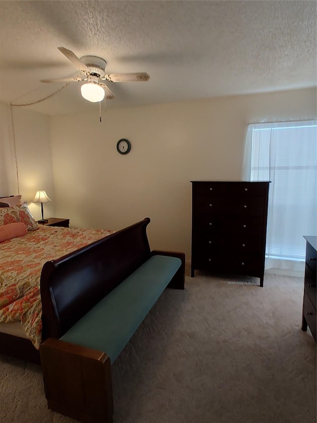 bedroom featuring carpet flooring, ceiling fan, and a textured ceiling