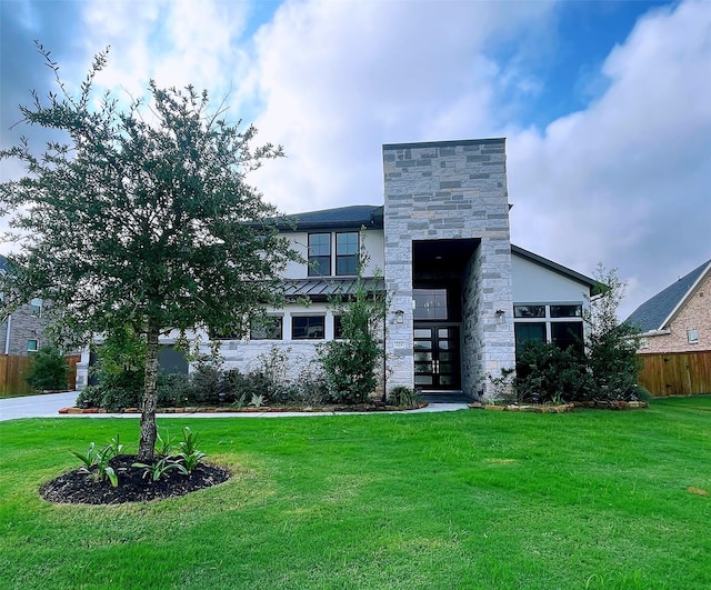 contemporary home featuring a front lawn and french doors