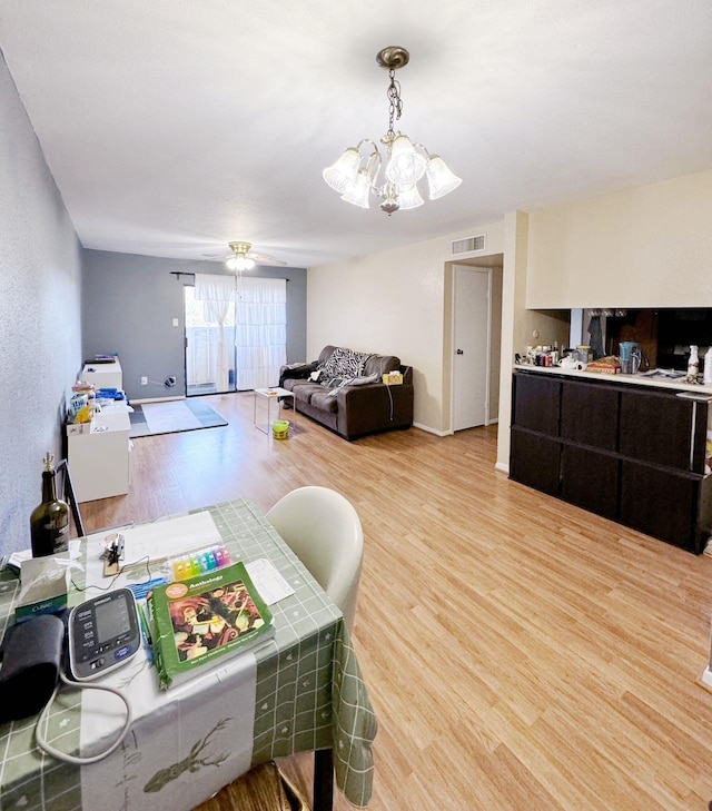 interior space with ceiling fan with notable chandelier and hardwood / wood-style flooring