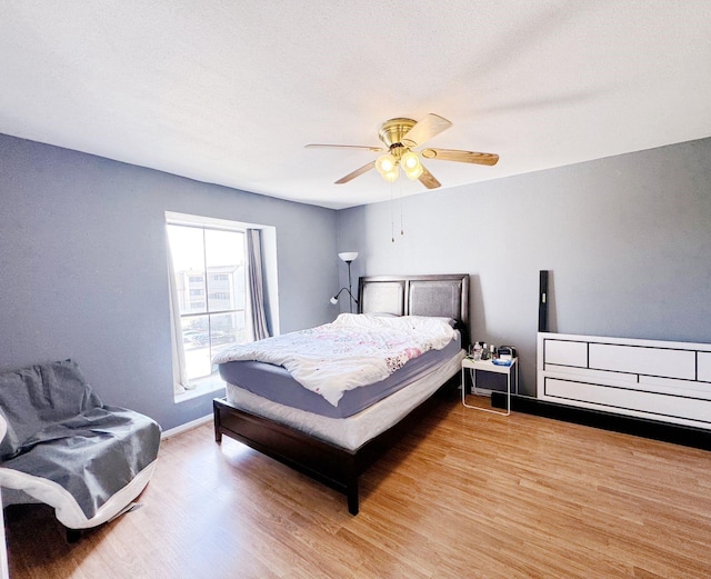 bedroom featuring a textured ceiling, light wood-type flooring, and ceiling fan