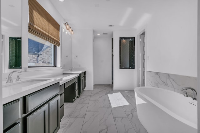 bathroom featuring a washtub and vanity