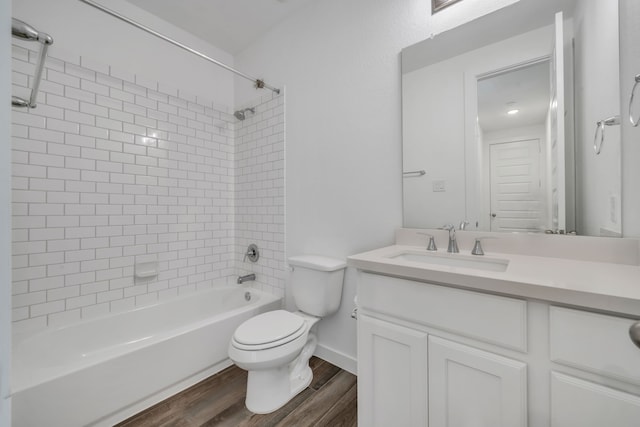 full bathroom with wood-type flooring, toilet, vanity, and tiled shower / bath