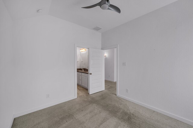 unfurnished bedroom featuring ceiling fan, light colored carpet, lofted ceiling, ensuite bath, and sink