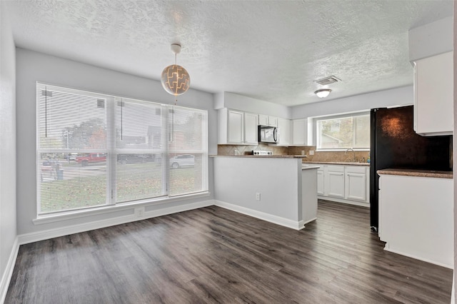 kitchen featuring dark hardwood / wood-style floors, pendant lighting, tasteful backsplash, white cabinets, and kitchen peninsula