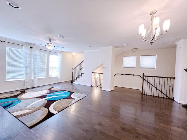 interior space with ceiling fan with notable chandelier, dark hardwood / wood-style flooring, and crown molding