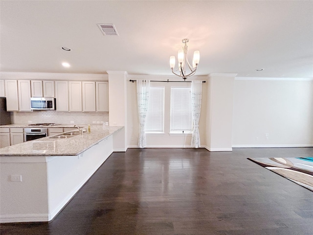 kitchen featuring white cabinetry, sink, hanging light fixtures, light stone counters, and appliances with stainless steel finishes