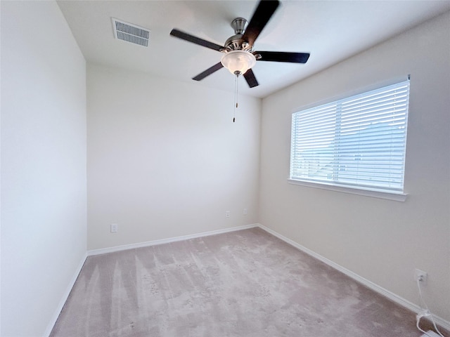 carpeted spare room featuring ceiling fan