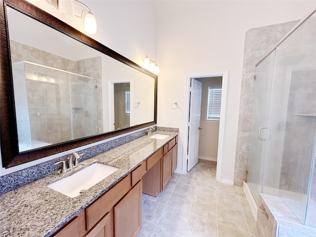 bathroom featuring tile patterned floors, vanity, and a shower with shower door