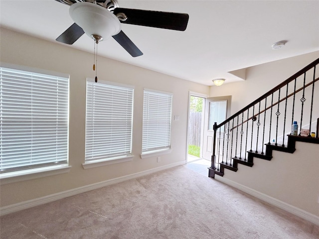 foyer entrance featuring ceiling fan and light carpet