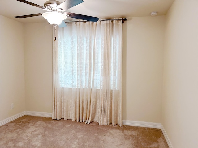 carpeted spare room featuring ceiling fan