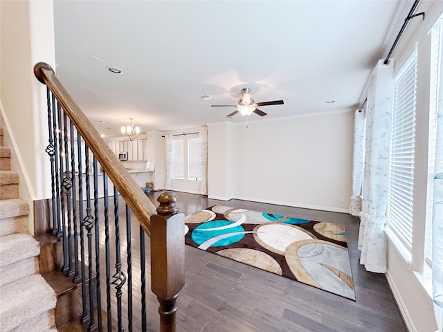 stairs with hardwood / wood-style floors, ceiling fan with notable chandelier, and ornamental molding