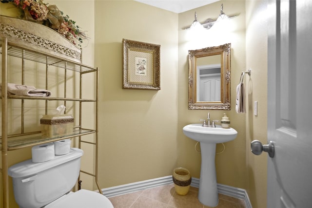 bathroom with tile patterned flooring, toilet, and sink