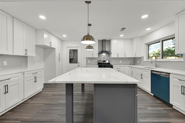 kitchen featuring appliances with stainless steel finishes, white cabinetry, wall chimney exhaust hood, and sink