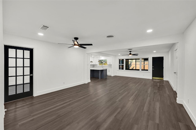 unfurnished living room with ceiling fan and dark wood-type flooring