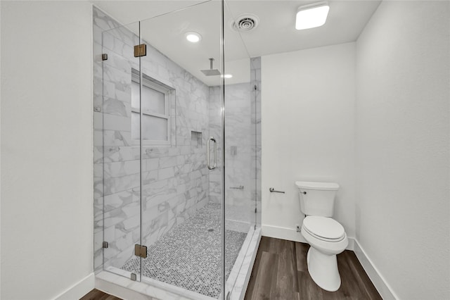 bathroom featuring wood-type flooring, an enclosed shower, and toilet