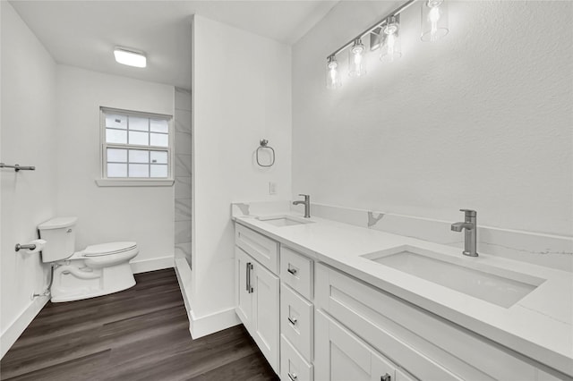 bathroom with wood-type flooring, vanity, toilet, and walk in shower