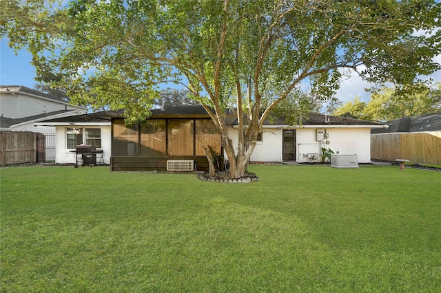 back of house with a lawn and a sunroom