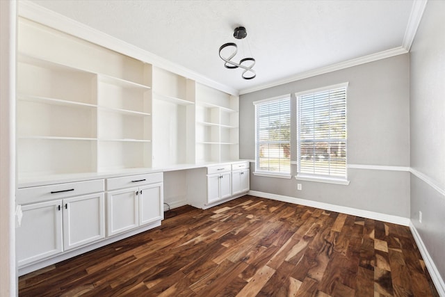 interior space with dark hardwood / wood-style flooring, built in desk, and ornamental molding