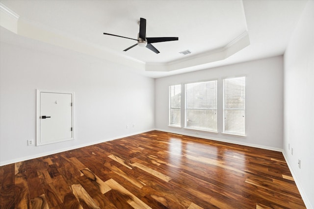 unfurnished room with ornamental molding, a raised ceiling, ceiling fan, and dark wood-type flooring