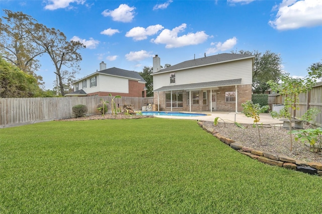 back of property featuring a fenced in pool, a patio area, and a lawn