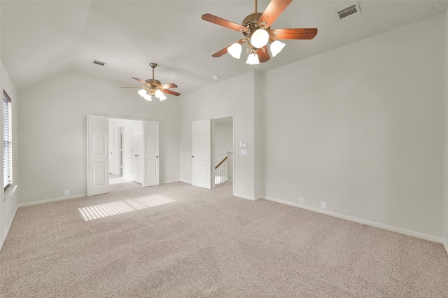 unfurnished room with light carpet and lofted ceiling