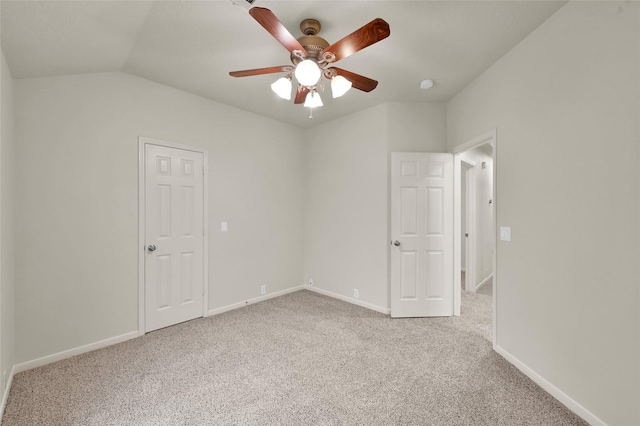 carpeted spare room featuring lofted ceiling and ceiling fan