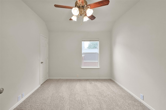 carpeted spare room featuring vaulted ceiling and ceiling fan