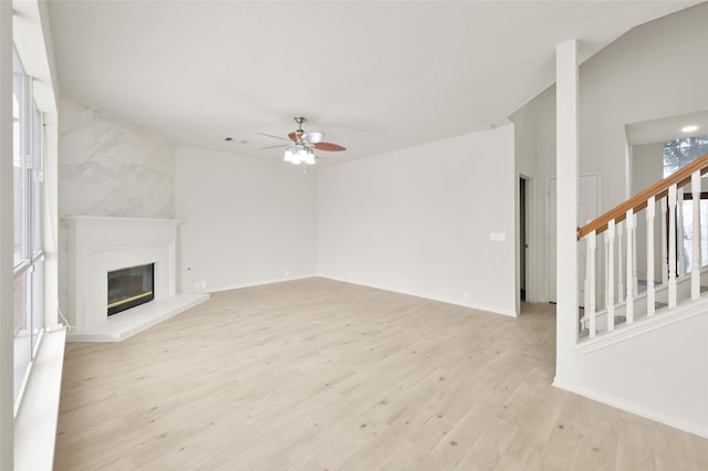 unfurnished living room featuring ceiling fan, vaulted ceiling, and light hardwood / wood-style flooring