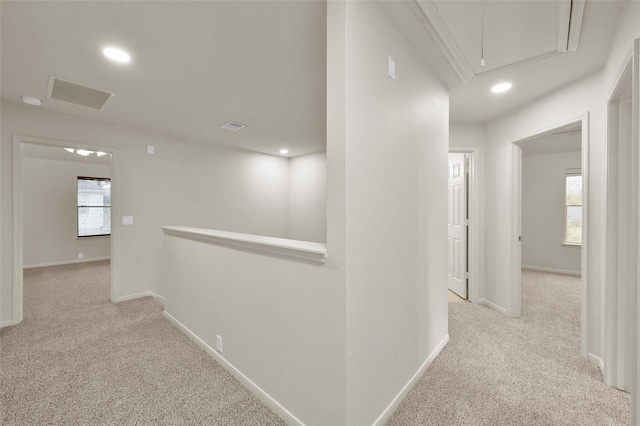 corridor featuring plenty of natural light and light colored carpet