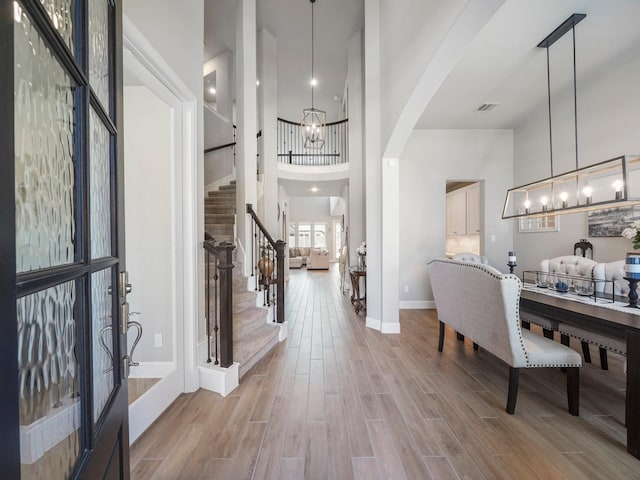 entrance foyer with light hardwood / wood-style floors, a high ceiling, and french doors